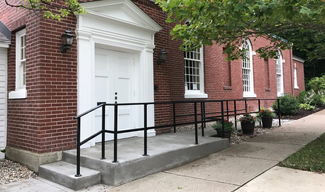 Brick building with white door and ramp.