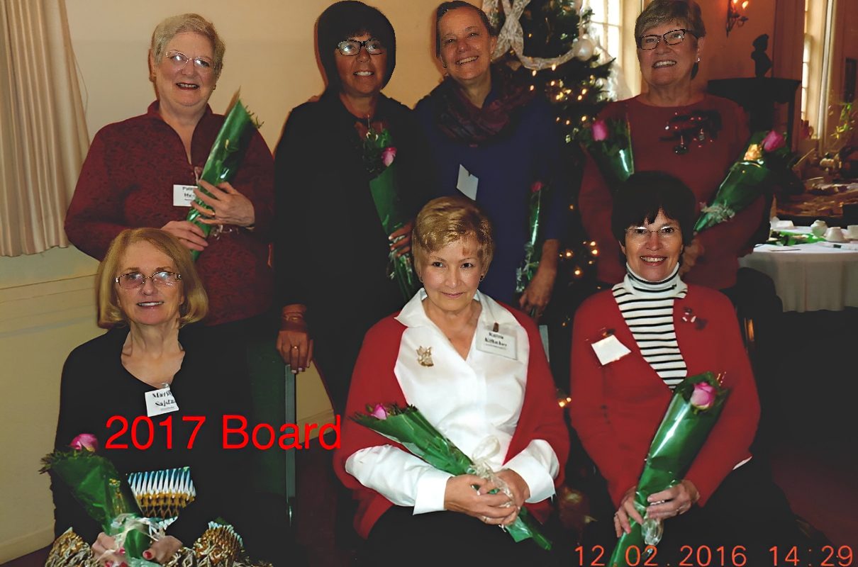 Smiling women board members holding flowers