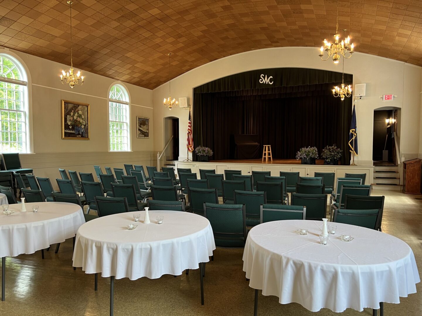 Small auditorium with stage and round tables
