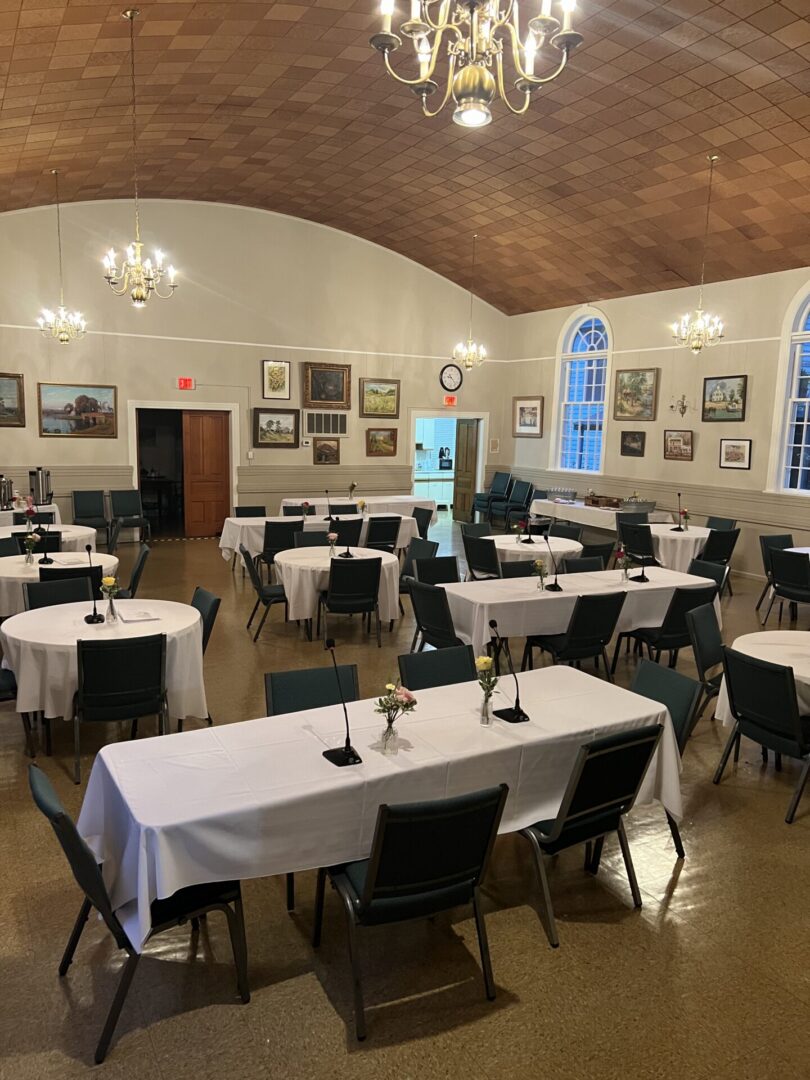 Community hall set with tables and chandeliers
